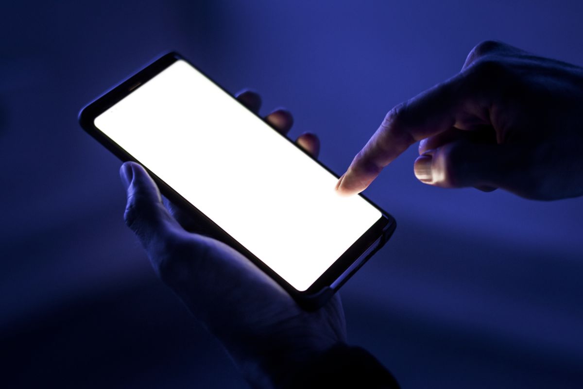 Hand tapping a bright smartphone screen – social media management by EP Digital